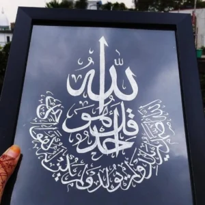 Framed Arabic calligraphy artwork on a dark background