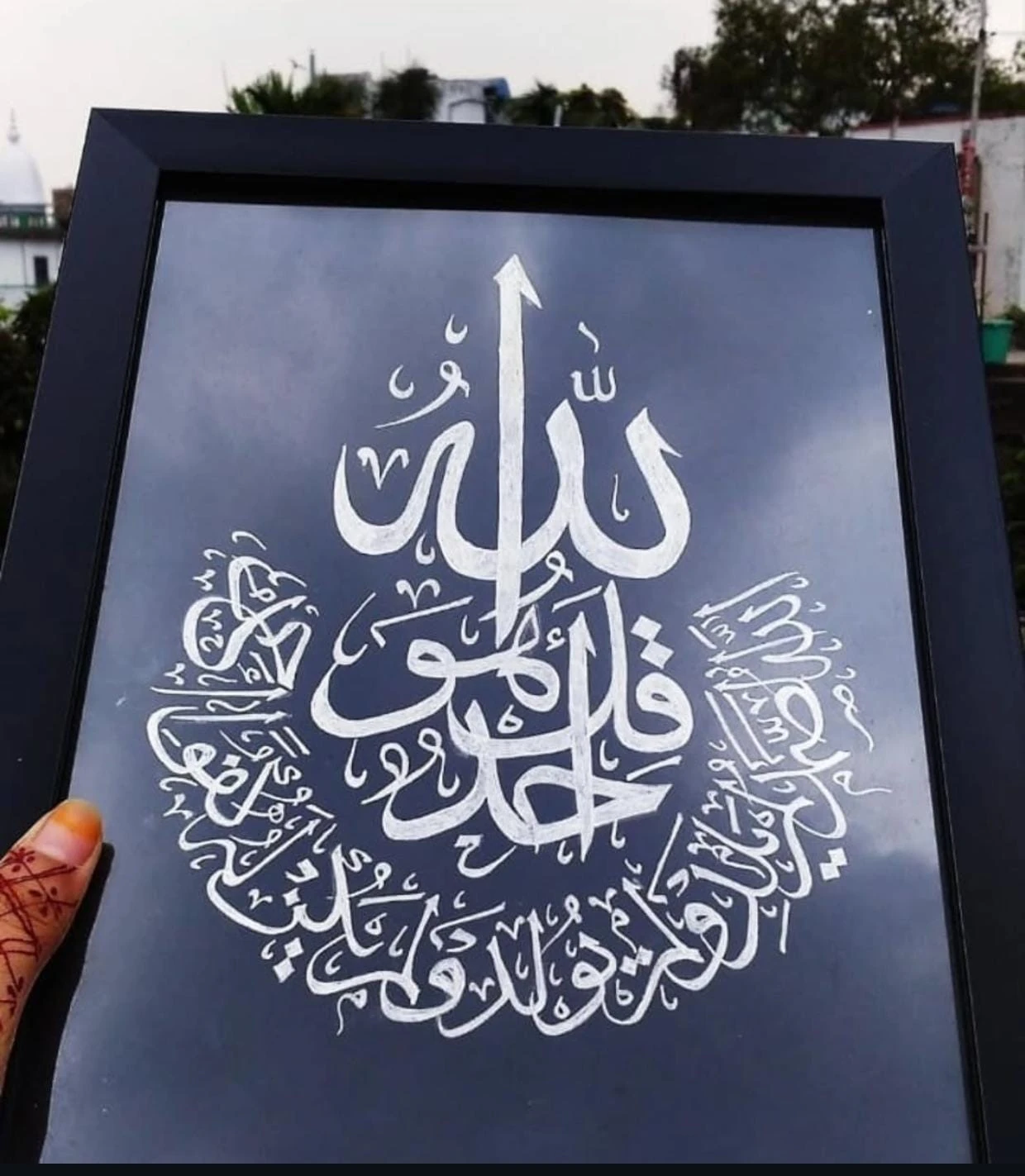 Framed Arabic calligraphy artwork on a dark background