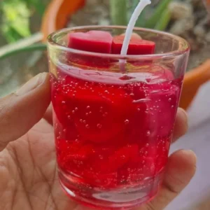 Red gel candle with visible bubbles in a clear glass